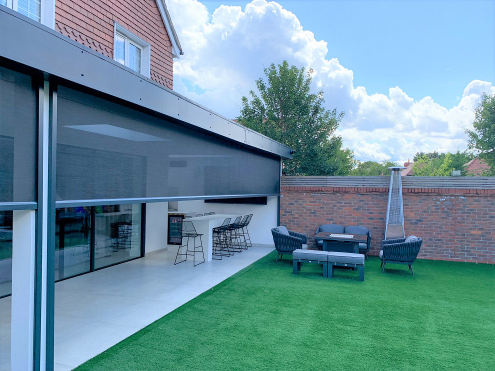 Inspiration for a large modern backyard verandah in Hertfordshire.