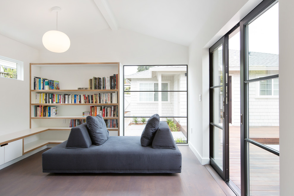 This is an example of a contemporary family room in San Francisco with white walls and dark hardwood floors.