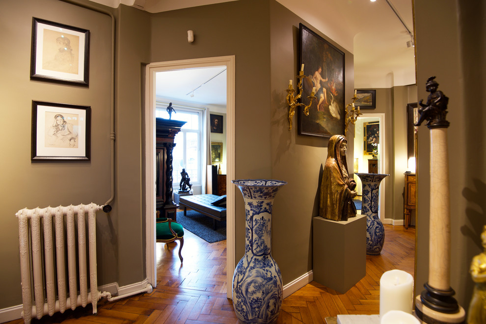 Design ideas for an eclectic hallway in Lille with grey walls and light hardwood floors.
