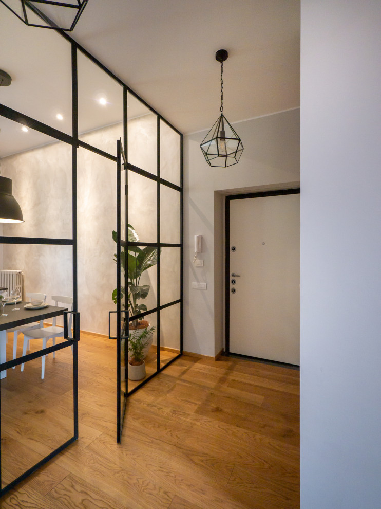 Photo of a large contemporary entrance in Milan with grey walls, light hardwood flooring, a single front door, a white front door and wallpapered walls.