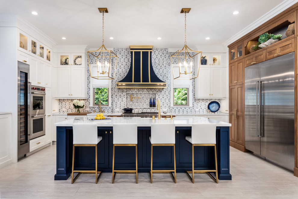 Design ideas for a mid-sized contemporary open plan kitchen in Los Angeles with a farmhouse sink, shaker cabinets, marble benchtops, multi-coloured splashback, glass tile splashback, stainless steel appliances, travertine floors, with island, grey floor and white benchtop.