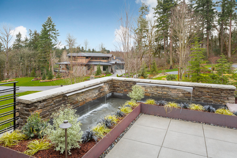 Mid-sized country garden in Seattle with a water feature and concrete pavers.