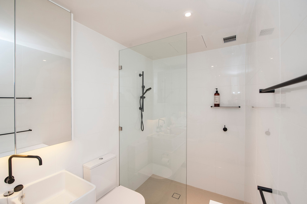 Mid-sized contemporary bathroom in Sydney with an alcove shower, a two-piece toilet, white tile, porcelain tile, white walls, ceramic floors, an integrated sink, beige floor and an open shower.