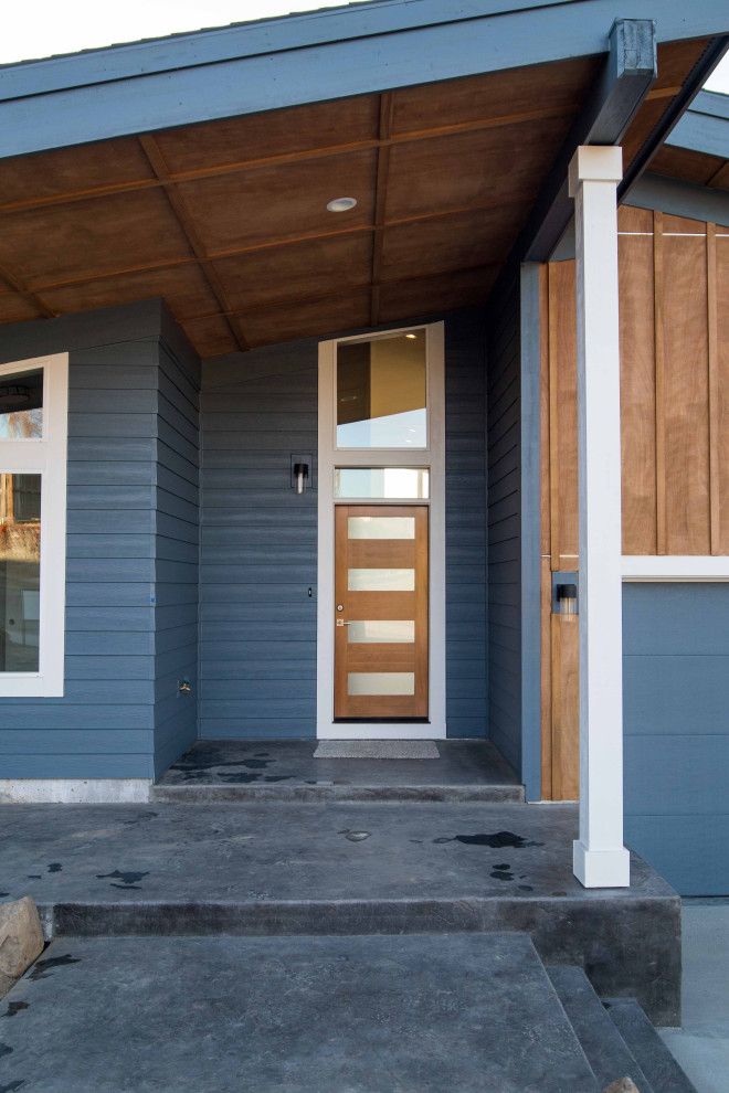 Ispirazione per la facciata di una casa blu moderna a un piano di medie dimensioni con rivestimenti misti, copertura a scandole, tetto nero e pannelli e listelle di legno