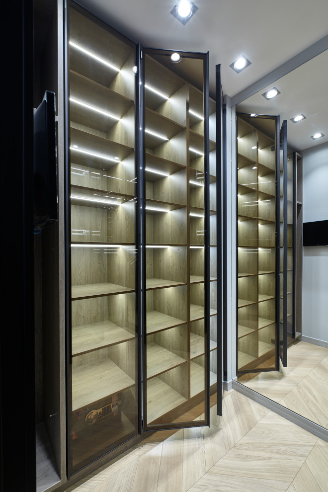Photo of a small contemporary gender neutral built-in wardrobe in Moscow with laminate floors and beige floors.