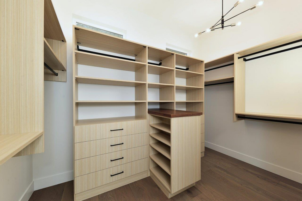 Photo of a large arts and crafts walk-in wardrobe in Other with flat-panel cabinets, light wood cabinets, laminate floors and brown floor.