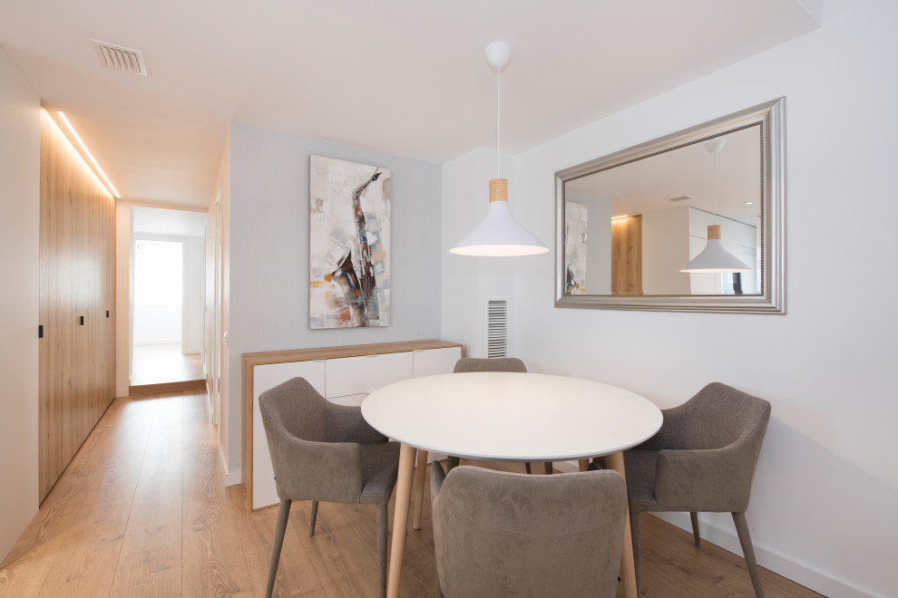 Diseño de comedor escandinavo de tamaño medio abierto sin chimenea con paredes blancas, suelo de madera en tonos medios y suelo marrón