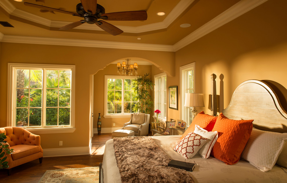 Photo of a large mediterranean master bedroom in Orlando with beige walls, dark hardwood floors and no fireplace.