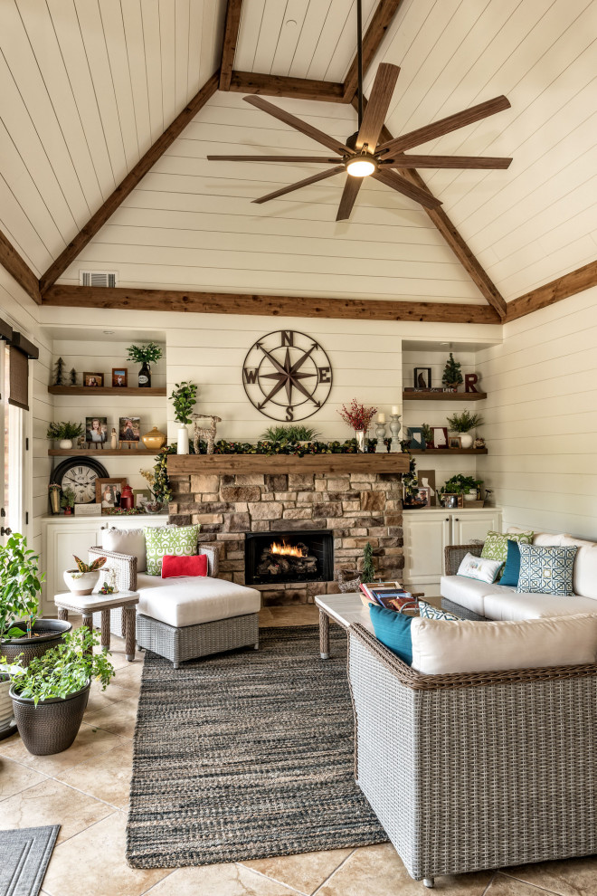 This is an example of a mid-sized traditional sunroom with porcelain floors, a standard fireplace, a stone fireplace surround and beige floor.