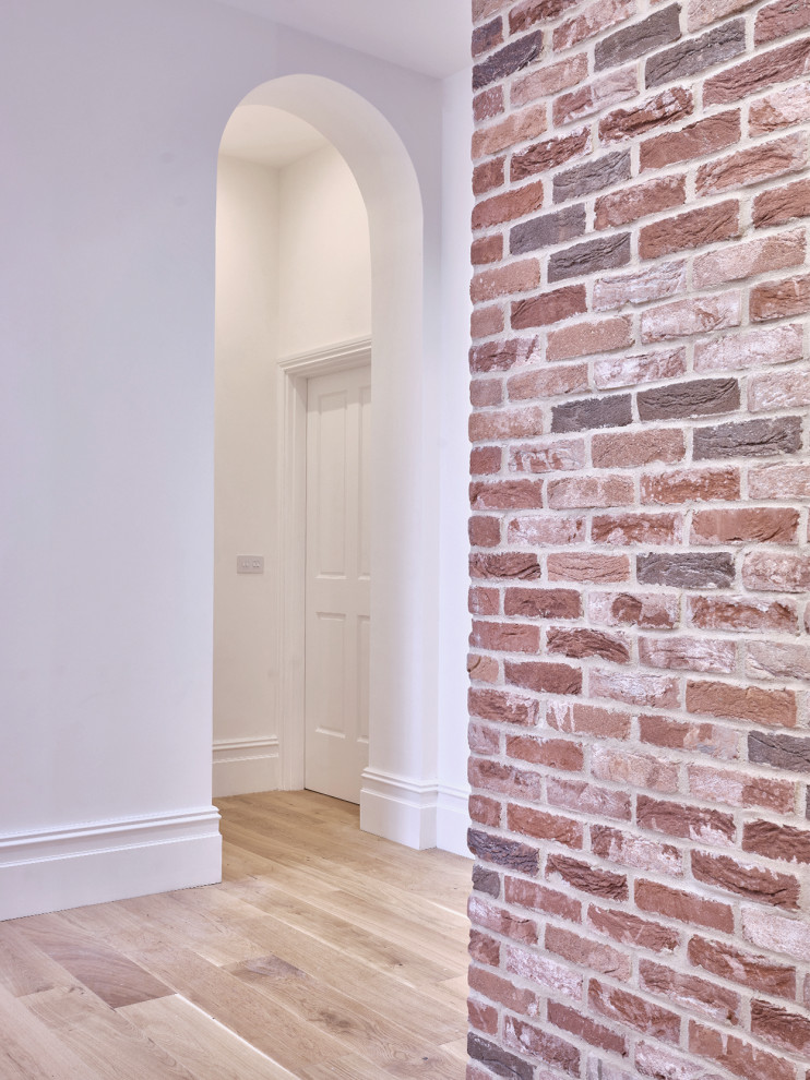 Источник вдохновения для домашнего уюта: большой коридор в современном стиле с красными стенами, паркетным полом среднего тона и кирпичными стенами