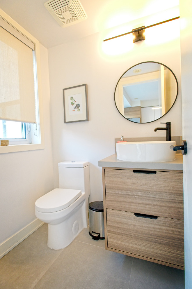 Photo of a small scandi cloakroom in Toronto with flat-panel cabinets, light wood cabinets, a one-piece toilet, white walls, porcelain flooring, a vessel sink, quartz worktops, grey floors, grey worktops and a floating vanity unit.