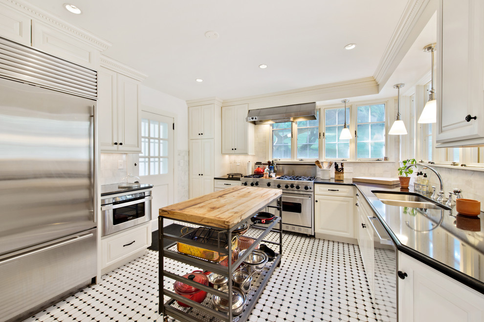 Traditional l-shaped kitchen in Denver with a double-bowl sink, raised-panel cabinets, white cabinets, white splashback, stainless steel appliances and with island.