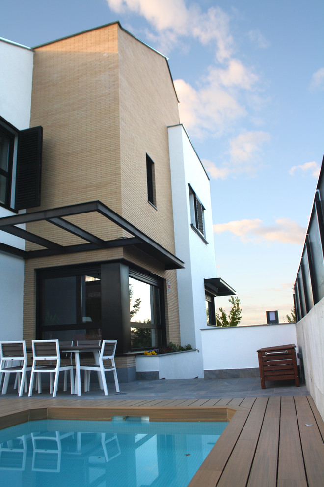 Imagen de piscina alargada moderna rectangular en patio trasero con entablado