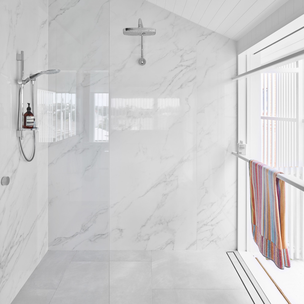 Exempel på ett mellanstort modernt vit vitt en-suite badrum, med luckor med infälld panel, vita skåp, en öppen dusch, en vägghängd toalettstol, vit kakel, marmorkakel, vita väggar, klinkergolv i keramik, ett integrerad handfat, bänkskiva i akrylsten, grått golv och med dusch som är öppen