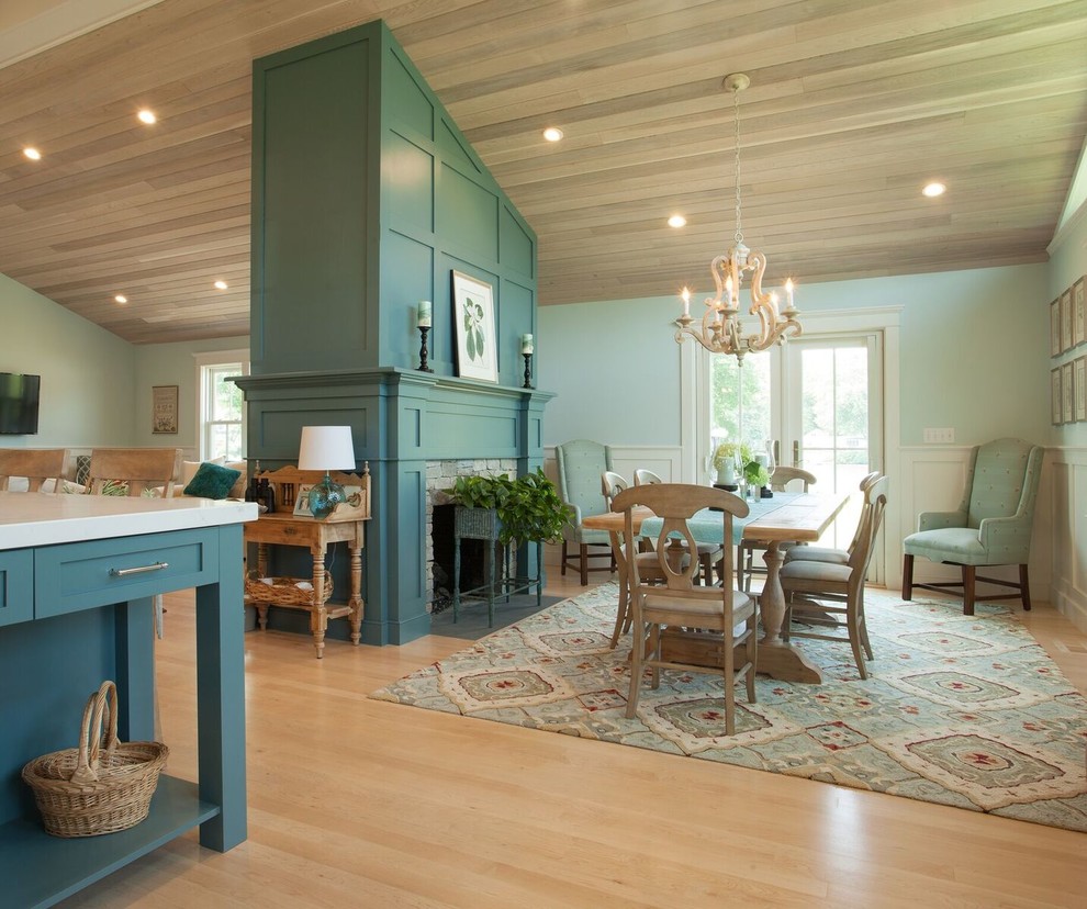 Photo of a mid-sized beach style kitchen/dining combo in Providence with blue walls, light hardwood floors, a two-sided fireplace and a stone fireplace surround.