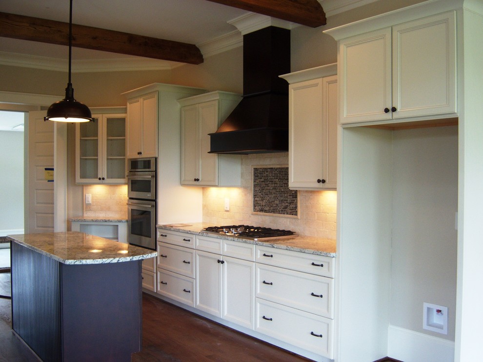 Example of a mid-sized eclectic galley light wood floor eat-in kitchen design with flat-panel cabinets, beige cabinets, granite countertops, beige backsplash, ceramic backsplash, stainless steel appliances and an island