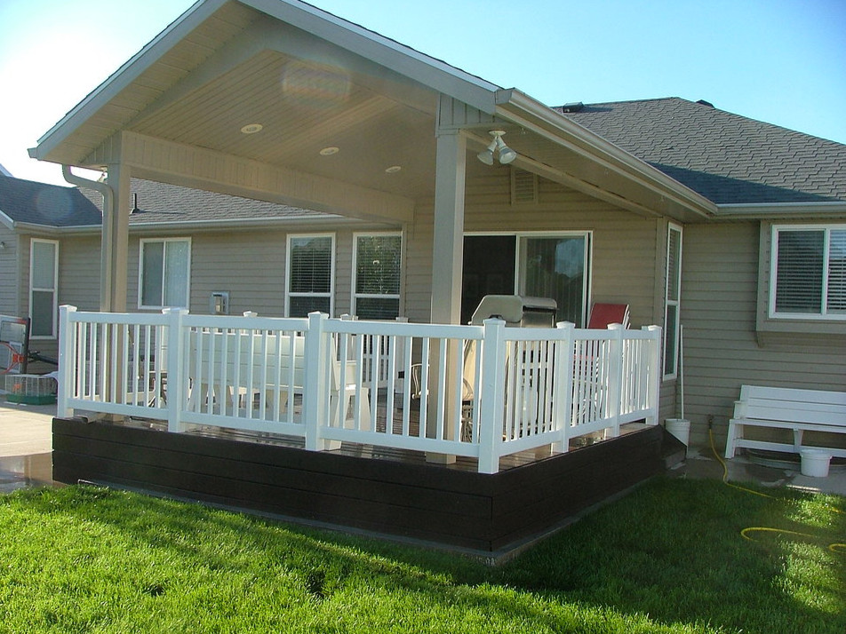 This is an example of a small traditional backyard deck in Salt Lake City with an outdoor kitchen and a roof extension.