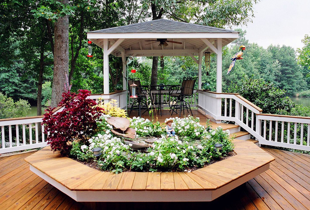 This is an example of a traditional backyard deck in Atlanta with a water feature.