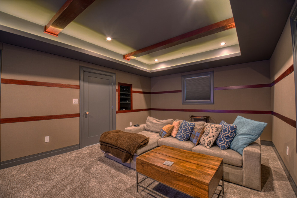This is an example of a small traditional enclosed home theatre in DC Metro with beige walls, carpet, a built-in media wall and grey floor.