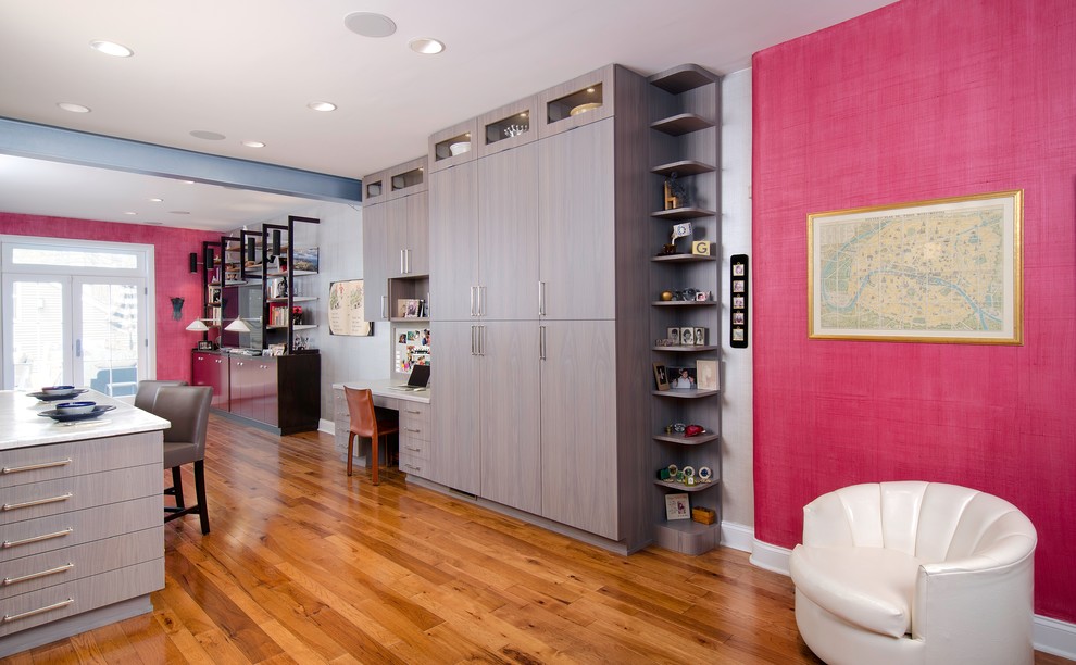 Photo of a mid-sized contemporary study room in Chicago with pink walls, dark hardwood floors, no fireplace, a built-in desk and brown floor.
