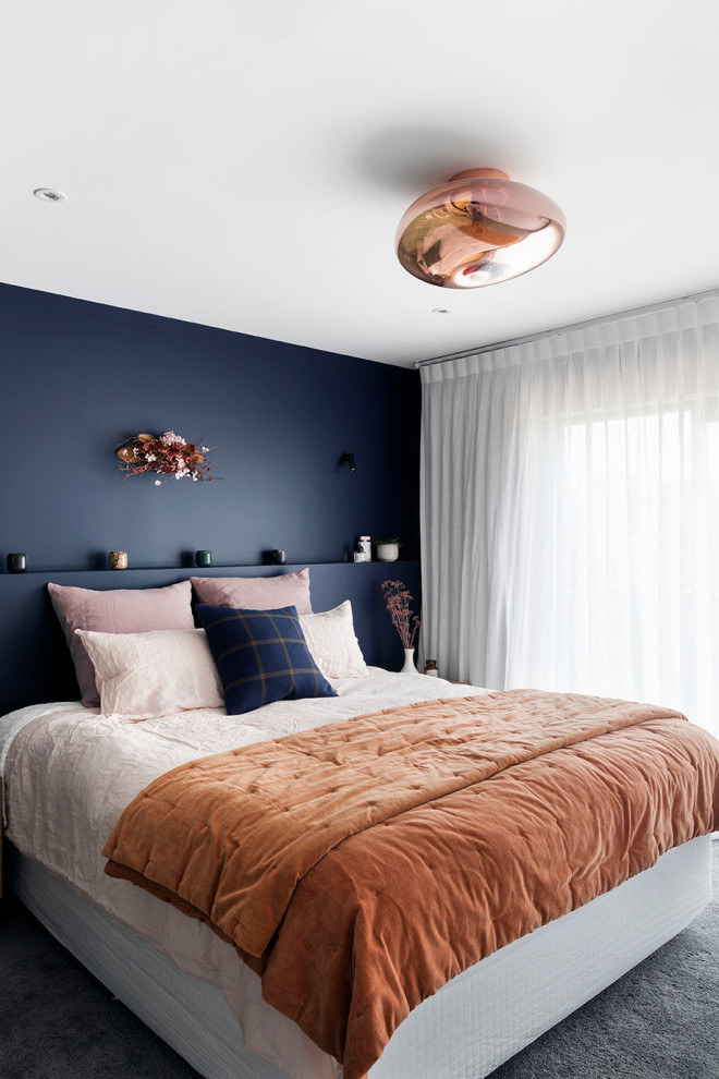 Contemporary master bedroom in Auckland with blue walls, carpet and grey floor.