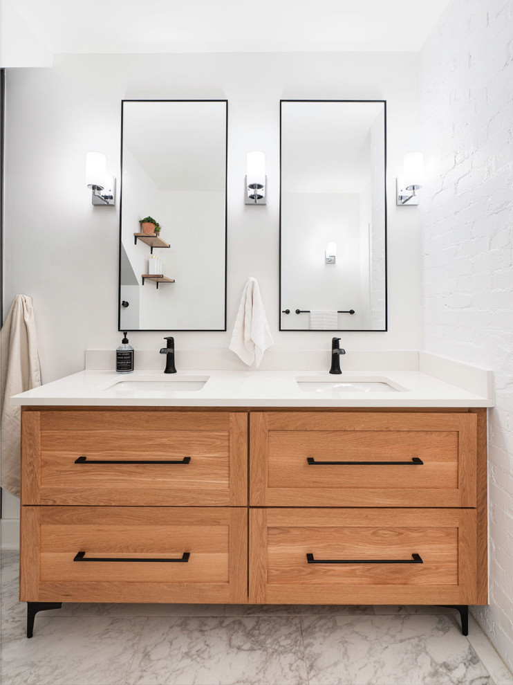 Design ideas for a mid-sized transitional bathroom in Columbus with shaker cabinets, light wood cabinets, an alcove tub, a shower/bathtub combo, white walls, porcelain floors, an undermount sink, engineered quartz benchtops, white floor, a hinged shower door, white benchtops, a double vanity and a built-in vanity.