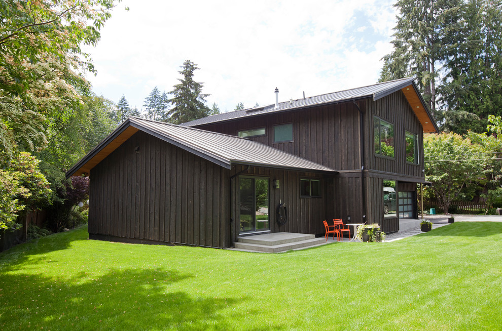Photo of a large transitional two-storey brown exterior in Vancouver with wood siding and a gable roof.