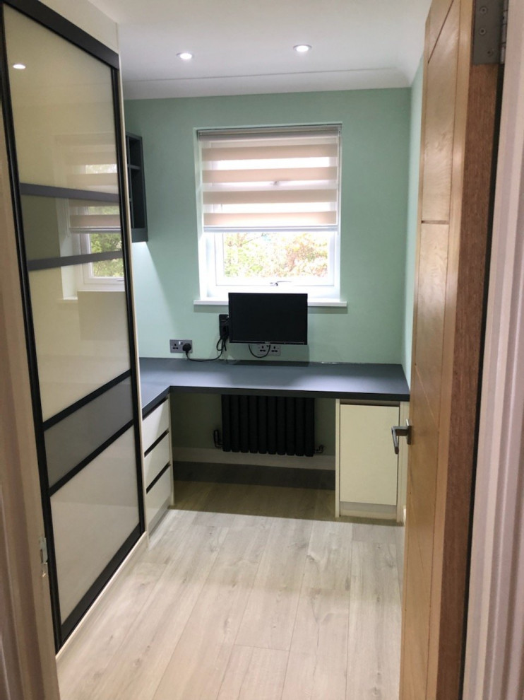 Exemple d'un petit bureau moderne avec un mur vert, parquet clair, un bureau intégré et un sol marron.