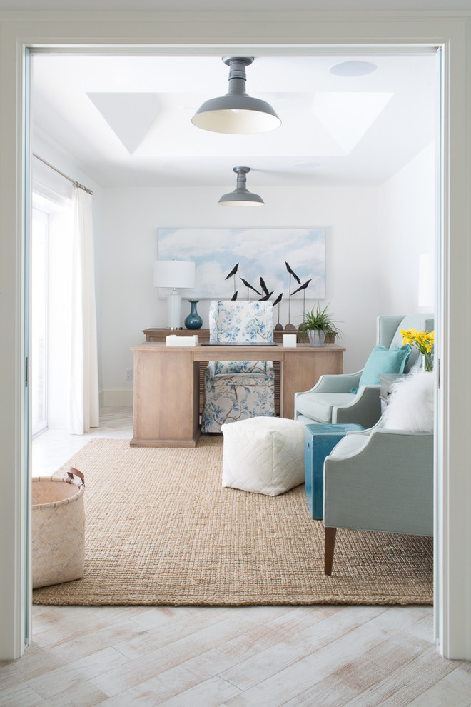 Inspiration for a mid-sized beach style study room in Miami with white walls, light hardwood floors, a freestanding desk and no fireplace.