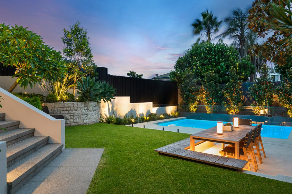 Immagine di una grande piscina design rettangolare dietro casa con paesaggistica bordo piscina e pavimentazioni in cemento