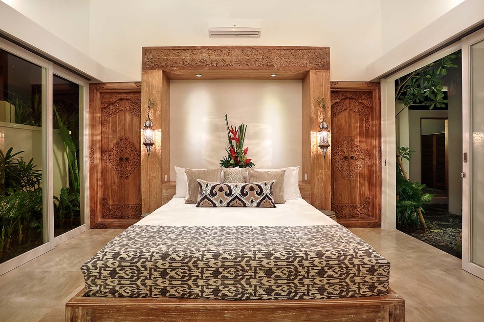 Inspiration for a mid-sized tropical master bedroom in Other with white walls and marble floors.