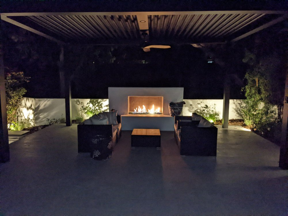 Trendy backyard tile patio photo in Orange County with a fireplace and a pergola