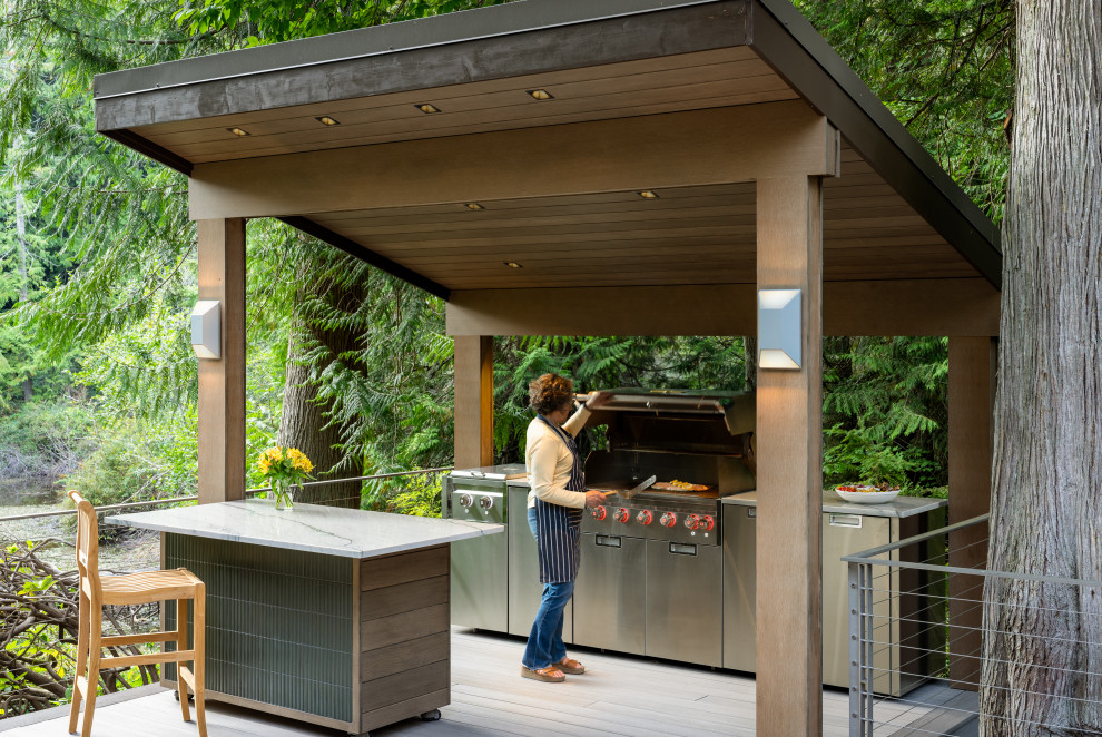 Large trendy backyard ground level metal railing outdoor kitchen deck photo in Seattle with a pergola