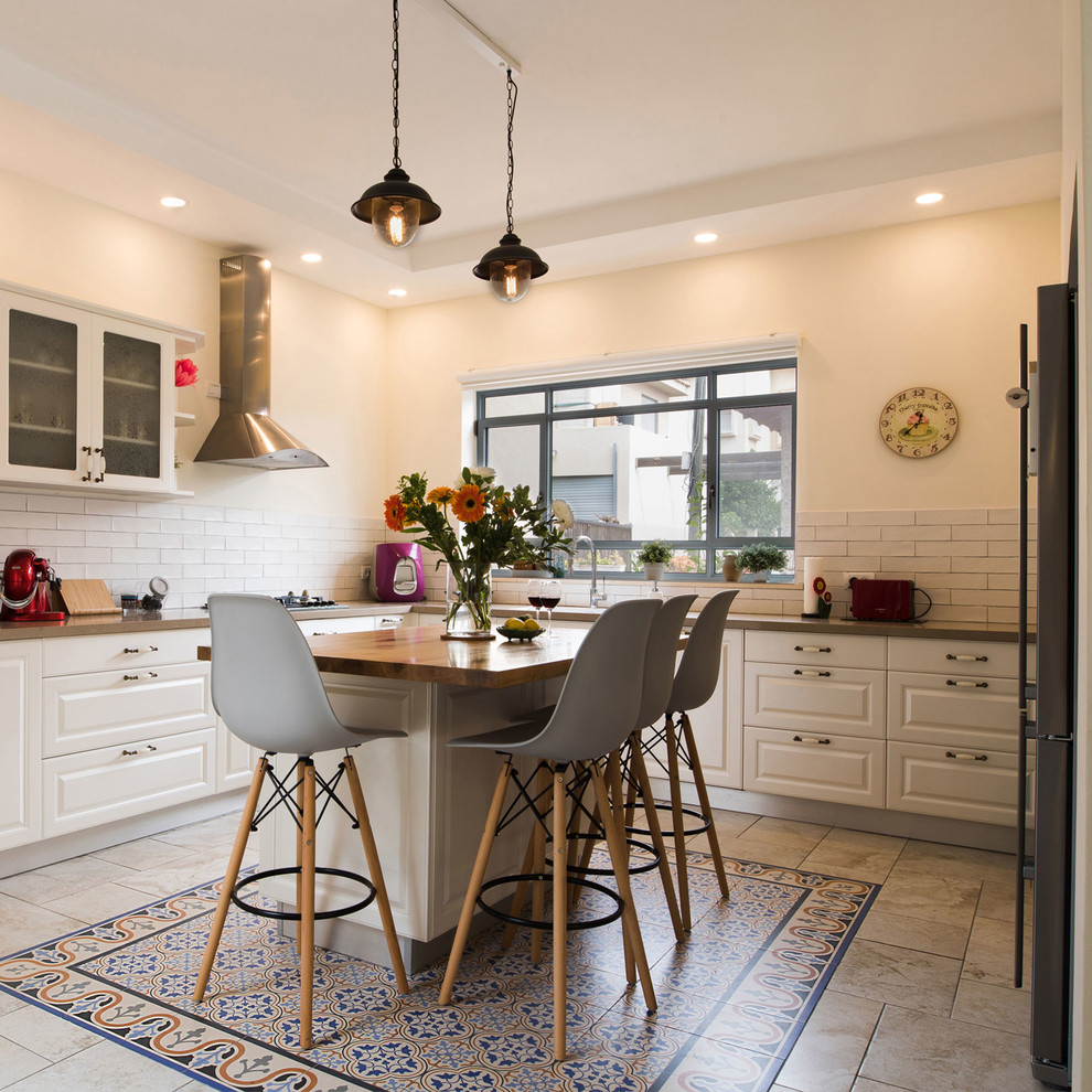 Photo of a large l-shaped eat-in kitchen in Other with an integrated sink, shaker cabinets, white cabinets, marble benchtops, white splashback, porcelain splashback, coloured appliances, with island, brown benchtop, ceramic floors and beige floor.