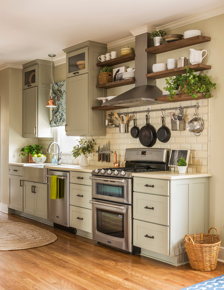 Design ideas for a mid-sized eclectic galley eat-in kitchen in Little Rock with a farmhouse sink, shaker cabinets, grey cabinets, quartzite benchtops, beige splashback, terra-cotta splashback, stainless steel appliances, medium hardwood floors and no island.