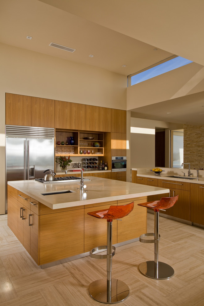 This is an example of a large modern l-shaped kitchen in San Francisco with flat-panel cabinets, medium wood cabinets, stainless steel appliances, an undermount sink, travertine floors and with island.