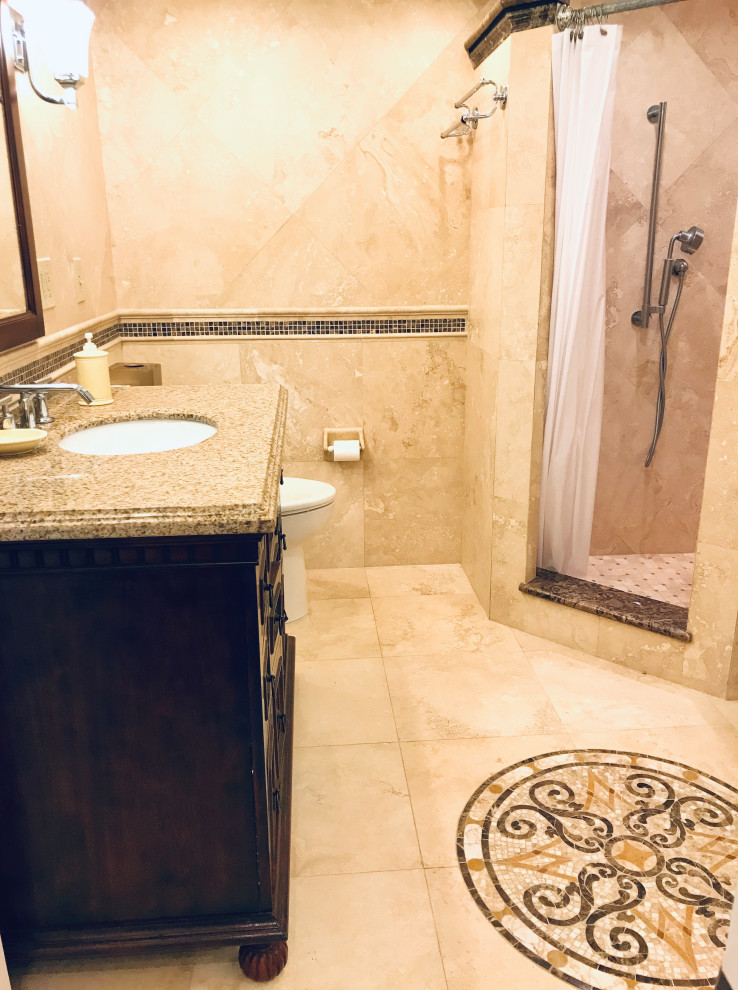 Cette photo montre une salle de bain méditerranéenne de taille moyenne avec un placard en trompe-l'oeil, des portes de placard marrons, un bain bouillonnant, une douche d'angle, WC à poser, un carrelage beige, du carrelage en travertin, un mur beige, un sol en travertin, un lavabo encastré, un plan de toilette en granite, un sol beige, une cabine de douche avec un rideau, un plan de toilette beige, meuble simple vasque et meuble-lavabo encastré.