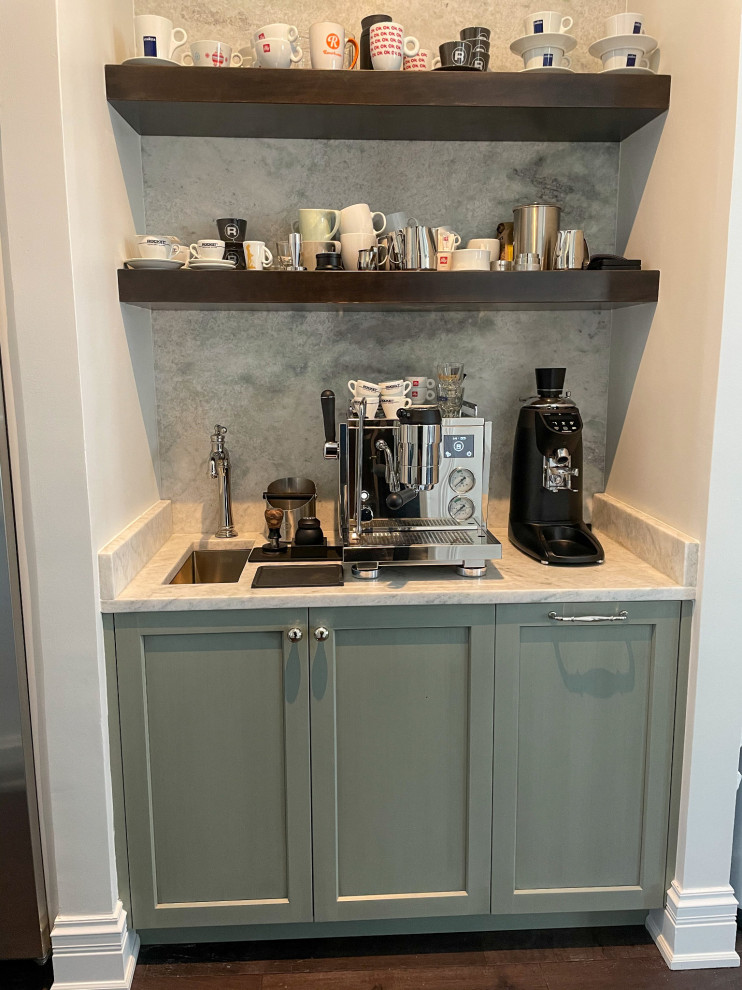 Small transitional u-shaped home bar in Chicago with an undermount sink, recessed-panel cabinets, green cabinets, quartzite benchtops, grey splashback, marble splashback, dark hardwood floors, brown floor and white benchtop.