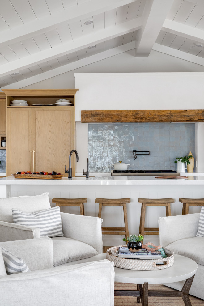 This is an example of a small beach style single-wall open plan kitchen in Orange County with shaker cabinets, white cabinets, quartz benchtops, blue splashback, terra-cotta splashback, panelled appliances, with island, white benchtop and vaulted.