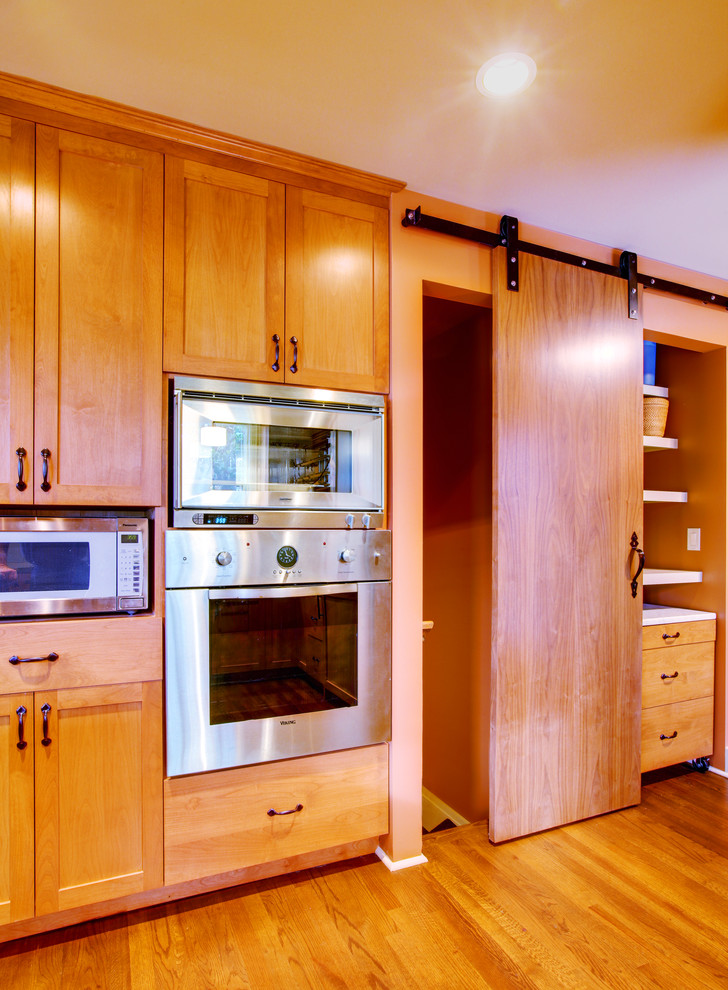 Mid-sized transitional u-shaped dark wood floor eat-in kitchen photo in Seattle with an undermount sink, shaker cabinets, medium tone wood cabinets, concrete countertops, green backsplash, ceramic backsplash, stainless steel appliances, gray walls and a peninsula