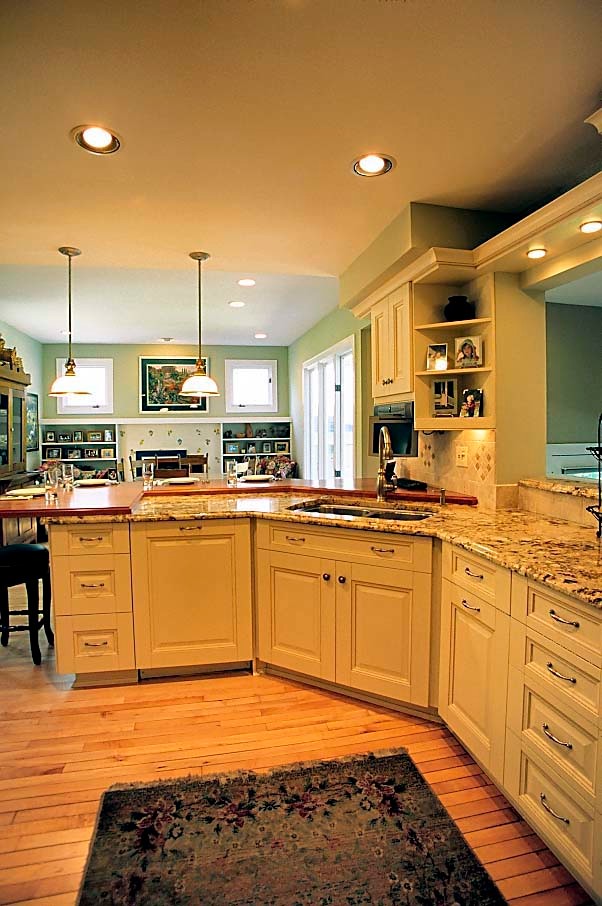 Inspiration for a mid-sized traditional u-shaped open plan kitchen in Chicago with a double-bowl sink, raised-panel cabinets, beige cabinets, granite benchtops, beige splashback, ceramic splashback, stainless steel appliances, medium hardwood floors and a peninsula.