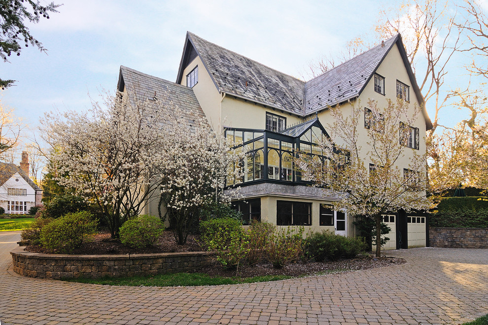 This is an example of a large traditional three-storey stucco white exterior in New York with a gable roof.