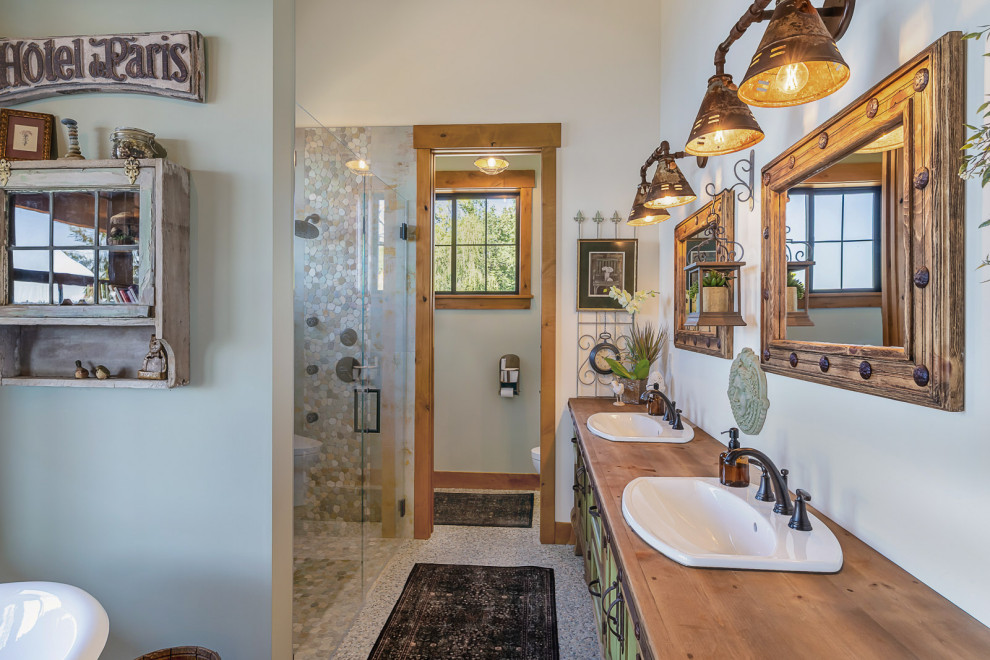 Inspiration for a mid-sized rustic master gray tile and porcelain tile porcelain tile, gray floor, double-sink and vaulted ceiling freestanding bathtub remodel in Seattle with shaker cabinets, green cabinets, a one-piece toilet, white walls, a drop-in sink, wood countertops, a hinged shower door, brown countertops and a built-in vanity
