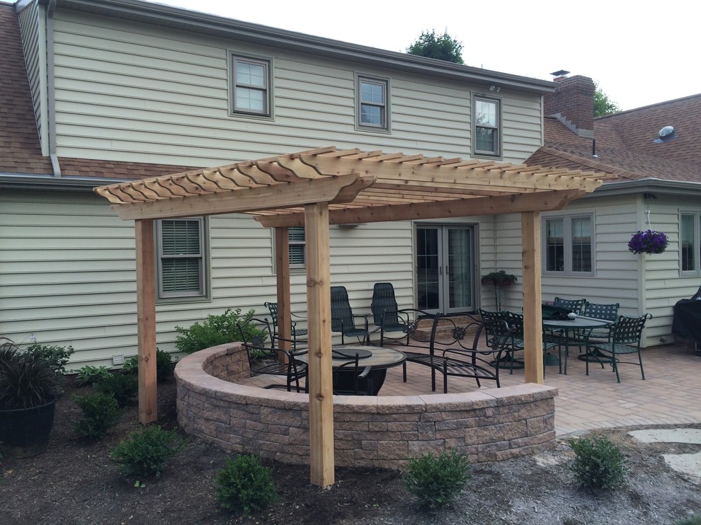 This is an example of a mid-sized arts and crafts patio in Philadelphia with natural stone pavers and a pergola.