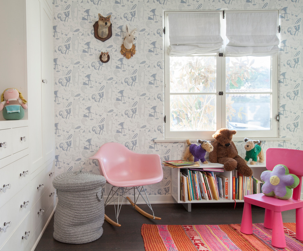 This is an example of a mid-sized mediterranean kids' room for girls in Los Angeles with multi-coloured walls, dark hardwood floors and brown floor.