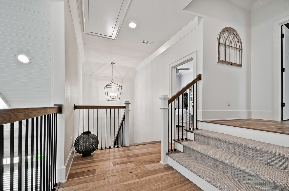 Design ideas for an arts and crafts wood u-shaped staircase in Other with carpet risers and metal railing.
