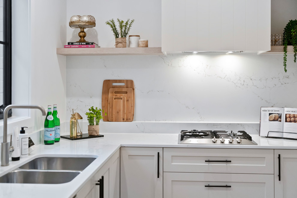 Inspiration for a small transitional l-shaped open plan kitchen in Sydney with a double-bowl sink, shaker cabinets, white cabinets, marble benchtops, marble splashback, stainless steel appliances, light hardwood floors, with island and white benchtop.