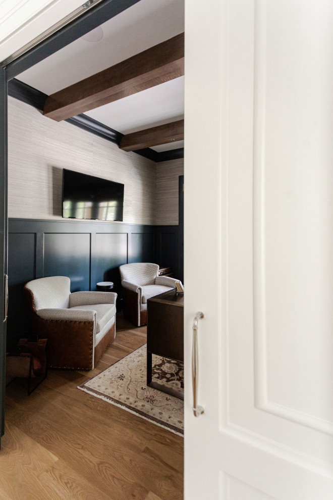 Diseño de despacho tradicional de tamaño medio con paredes grises, suelo de madera en tonos medios, escritorio independiente, vigas vistas y papel pintado