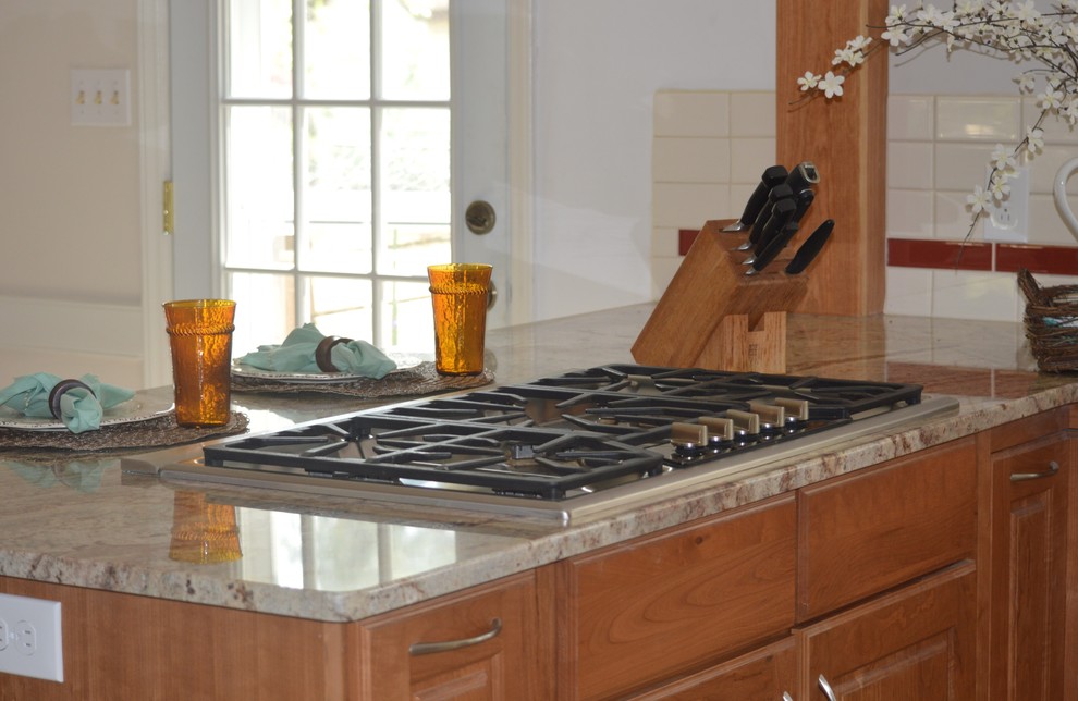 Eat-in kitchen - large transitional l-shaped porcelain tile and beige floor eat-in kitchen idea with a farmhouse sink, raised-panel cabinets, brown cabinets, granite countertops, white backsplash, ceramic backsplash, stainless steel appliances and a peninsula