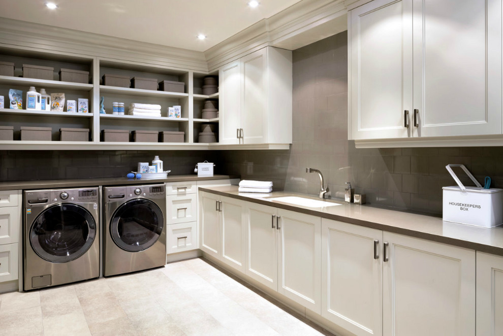 Inspiration for a large transitional l-shaped dedicated laundry room in Miami with an undermount sink, recessed-panel cabinets, white cabinets, quartz benchtops, beige walls, ceramic floors, a side-by-side washer and dryer, beige floor and brown benchtop.